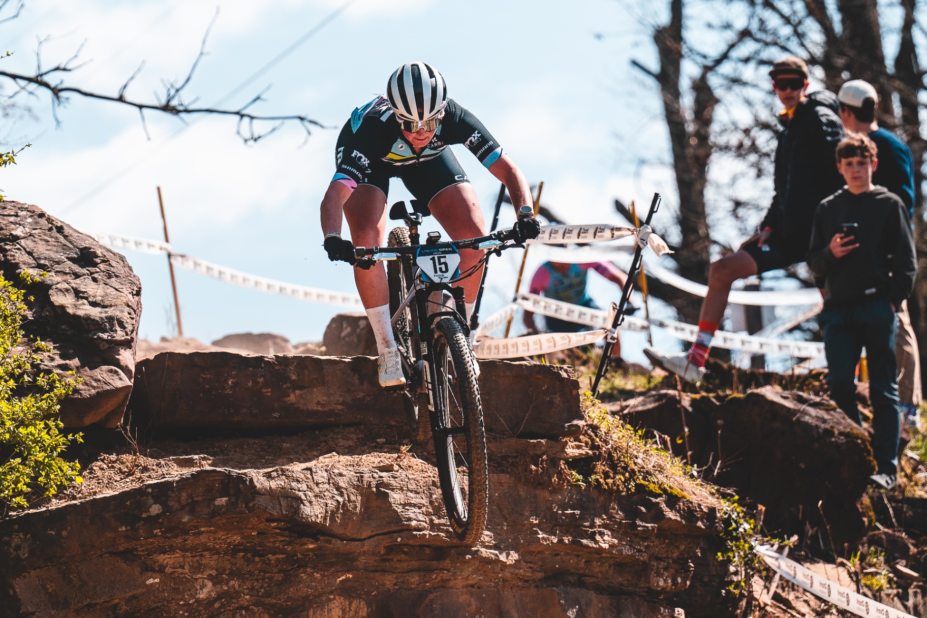 Bayli attacking a rocky drop on the XC race course, bib #15