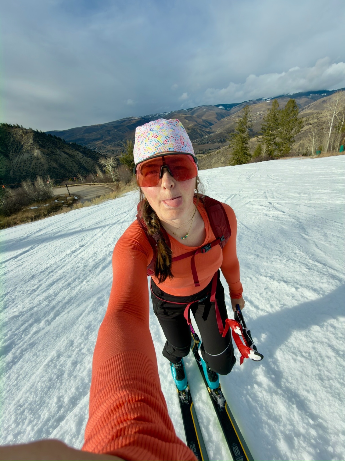 Skimo selfie in an orange base layer on a groomed piste above the Vail Valley