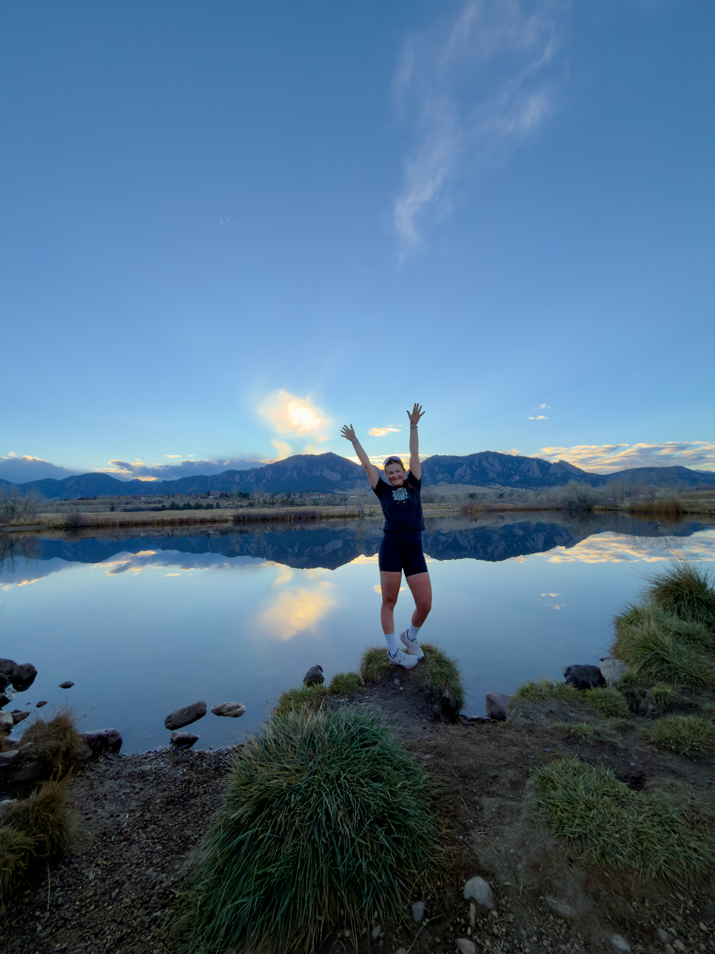 Bayli celebrating at sunset with the Flatirons behind her