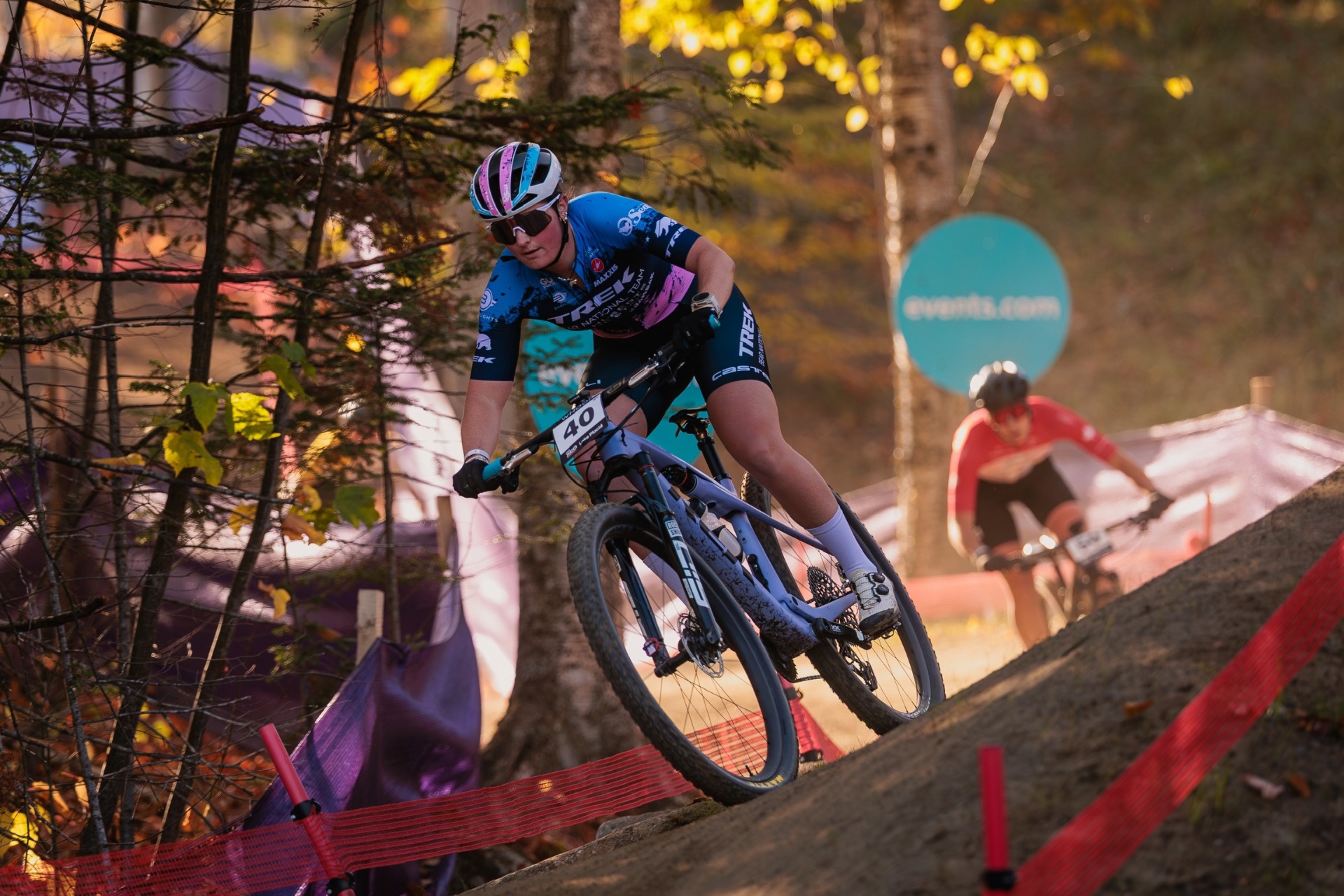 Bayli #40 riding the Trek USA National Team kit through a dusk-lit forest in Mont-Sainte-Anne